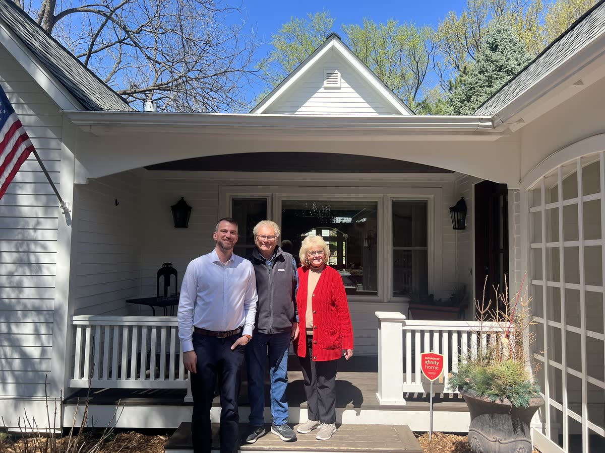 Andrew Malm with clients on the porch of their new home